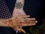 Laura gets henna on her wrist (one with the smaller design is hers)