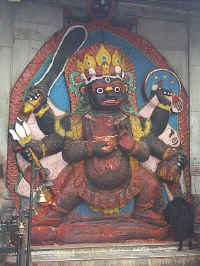 So many hands, so little time! Giant Nepalese deity lovingly covered with red dye