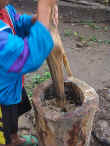Grinding ginger in a hollowed stump outside the kitchen - for almost every meal