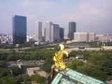 Osaka's skyline as seen from over a fish fixture at the top of Osaka-jo